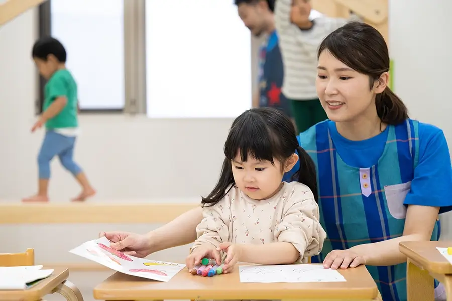 先生と一緒に制作遊びをする子供 写真